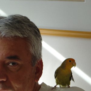 Pseudomyxoma survivor Milton with his pet bird on his shoulder